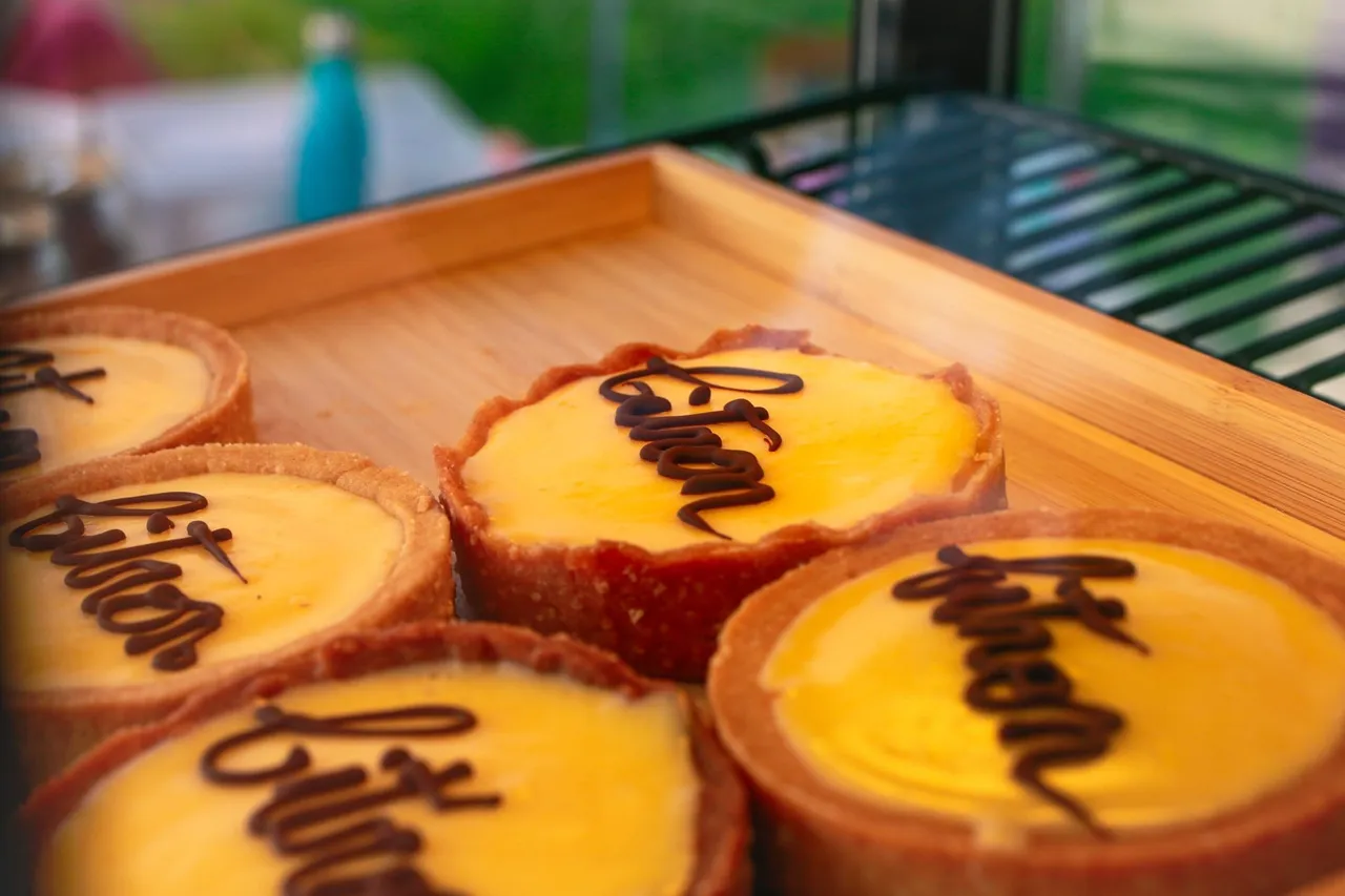 Des tartelettes jaunes décorées d’une inscription en chocolat