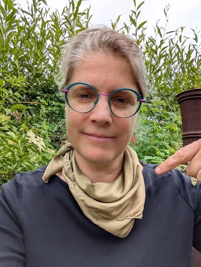 Portrait d’une femme souriante à lunettes, en extérieur
