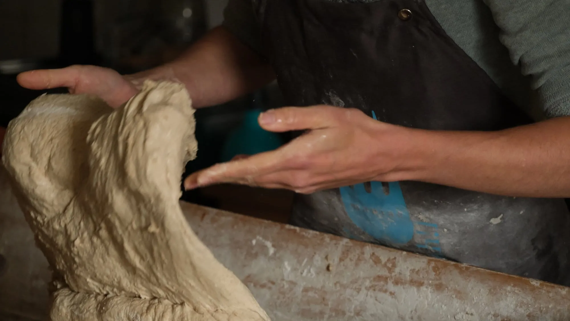 Des mains pétrissent une pâte à pain