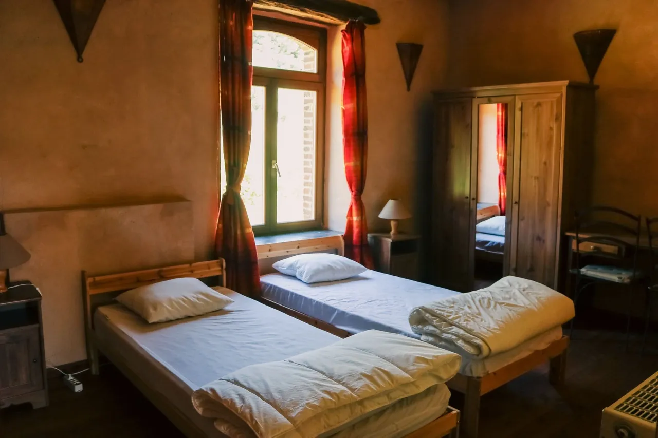 Une chambre avec deux lits simples sous la fenêtre